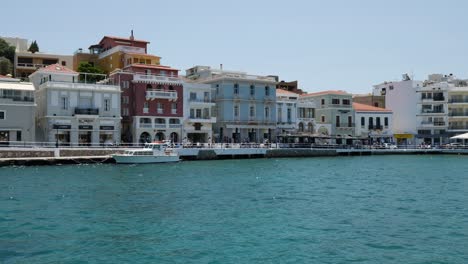 Tourist-visiting-Agios-Nikolaos-with-restaurant-in-summer