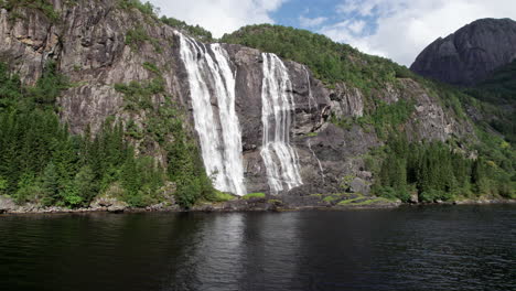 Slow,tight-pan-around-a-tall-waterfall,-Laukelandsfossen,-in-Norway