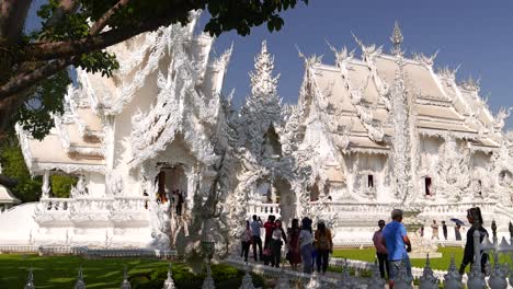 People-looking-around-grounds-of-famous-White-temple-in-Chiang-Rai,-Thailand