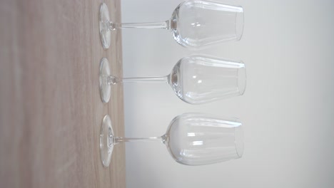 Empty-white-wine-glass-between-two-red-wine-glasses-on-wooden-table
