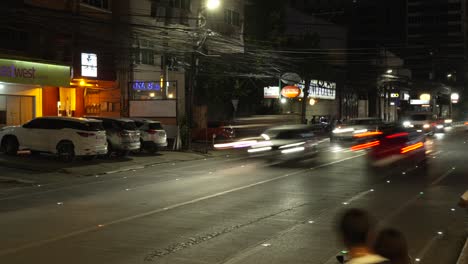 Busy-city-street-in-Cebu,-Philippines-at-night-with-light-trails-from-moving-vehicles,-timelapse