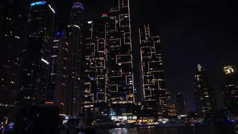 Dubai-Marina-Skyscrapers-and-Waterway-at-Night,-Lights-and-Towers