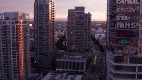 Fasting-panning-aerial-shot-of-the-Oceanwide-Plaza-graffiti-towers-at-sunset-in-downtown-Los-Angeles,-California