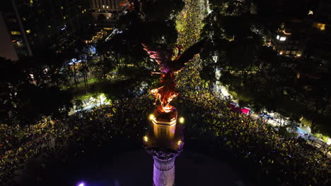 Crowd-celebrating-at-the-Monument-to-Independence,-night-in-CDMX---Aerial-view