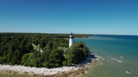 Drone-aerial-shot-pulling-back-from-a-light-house-on-the-shores-of-door-county,-WI