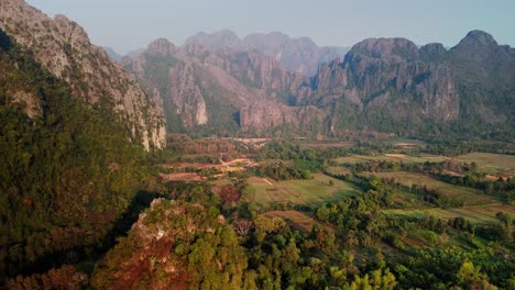 Kalksteinformationen-In-Ländlicher-Umgebung,-Mit-Laos-Flagge-Auf-Einem-Hügel