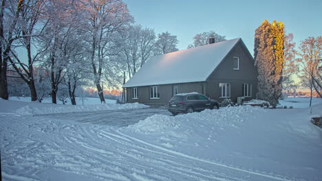 Snow-covered-countryside-home-with-glowing-sun-in-winter-season