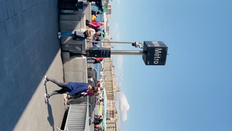 People-move-by-metro-station-by-Old-Port-in-sunny-Marseille,-vertical