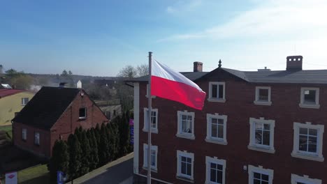 polish-flag-wave-on-wind-aerial-circulating-sunny-day-poland-church