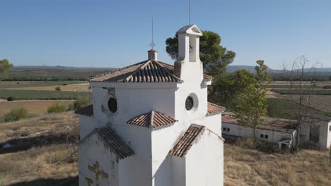 Descending-aerial-of-the-timeless-beauty-of-La-Ermita-del-Poblado-de-San-Julián-,-a-historic-church-nestled-in-the-heart-of-Marmolejo,-the-concept-of-cultural-and-religious-significance