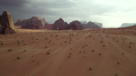 Menschen-In-Der-Riesigen-Wüstenlandschaft-Wadi-Rum-In-Jordanien,-Filmische-Luftaufnahmen
