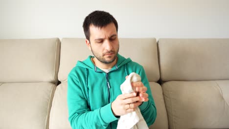 Man-covering-an-ice-with-a-cloth-to-apply-it-on-his-face-after-wisdom-teeth