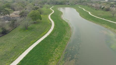 Una-Vista-Aérea-De-Arriba-Hacia-Abajo-De-Un-Macho-Adulto-En-Bicicleta-Alrededor-De-Exploración-Verde-En-Clear-Lake,-Houston,-Texas.