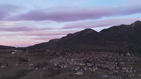 Mountain-town-at-sunrise,-pink-sky-and-clouds