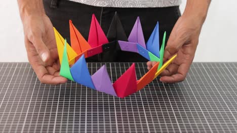 Hands-showing-colorful-rainbow-paper-handmade-crown,-crafting