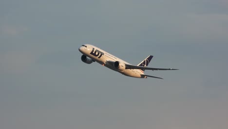 Polish-airline-taking-off-at-sunset-from-Toronto-Pearson-International-Airport,-partly-cloudy-sky