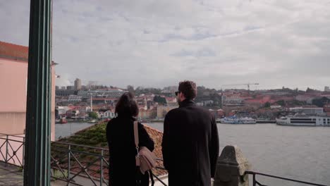 Romantisches-Paar,-Das-Sich-Unterhält-Und-Auf-Die-Uferpromenade-Von-Porto-Entlang-Des-Flusses-Douro-Zeigt-Und-Gemeinsam-Malerische-Orte-Der-Stadt-Erkundet