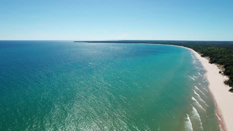 Beautiful-drone-shot-panning-to-the-right-of-the-colorful-waters-of-lake-Michigan