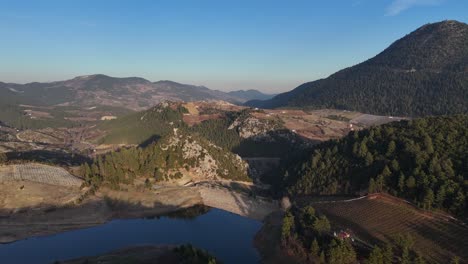 Drohnenansicht-Des-Staudamms-In-Der-Mitte-Des-Landes,-Umgeben-Von-Hohen-Bergen