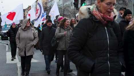 Covid-regulation-protesters-march-with-flags-in-winter-in-Stockholm