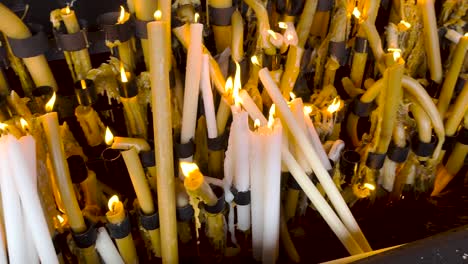 Close-up-gimbal-shot-of-candle-offering-in-Sanctuary-of-Fatima,-Portugal