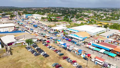 Los-Espectadores-Estacionan-Sus-Autos-Para-Alinearse-A-Lo-Largo-De-Puestos-Vibrantes-Antes-De-La-Gran-Marcha-De-Karnaval,-Curacao-Aéreo.