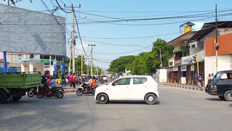 Busy-traffic-of-cars,-scooters-and-microlet-buses-with-people-at-rush-hour-in-capital-city-centre-of-East-Timor,-Southeast-Asia