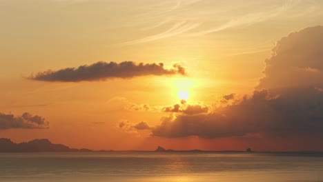 Panoramic-view-of-sun-setting-before-clouds,-sun-rays-distinctly-visible-falling-along-cloudscape