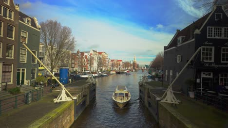 Crucero-Por-El-Canal-Navega-En-El-Río-Ámsterdam-Junto-A-La-Famosa-Casa-Sluyswacht