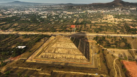 Pyramid-of-the-sun,-sunlit-by-the-morning-sunlight,-in-Teotihuacan,-Mexico---Aerial-view
