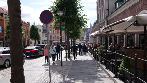 Streets-of-Bergen-Norway-on-Sunny-Summer-Day,-People-on-Sidewalk,-Shops-and-Restaurants,-Slow-Motion