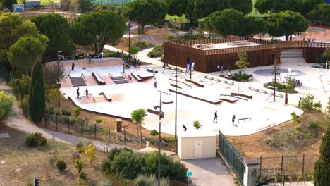 Toma-Aérea-De-Establecimiento-De-Personas-Usando-El-Nuevo-Skatepark-En-Montpellier