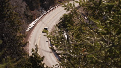 Un-Todoterreno-Conduce-Por-Una-Sinuosa-Carretera-De-Montaña-En-El-Bosque,-Lente-Larga