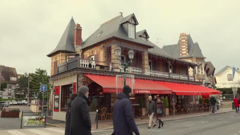 Le-Hastings-Restaurant-Mit-Passanten-Auf-Der-Straße-Tagsüber-In-Cabourg,-Frankreich