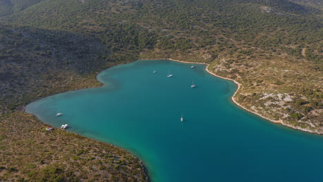 Aerial:-Panoramic-shot-of-natural-harbor-the-bay-of-Planitis-in-Kira-Panagia-island,-Sporades,-Greece
