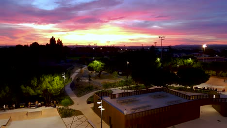 Aerial-dolly-shot-revealing-skaters-enjoying-the-skatepark-during-a-sunset