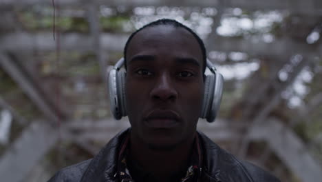 Confident-and-cool-looking-Black-man-in-urban-garden-environment-wears-wireless-headphones
