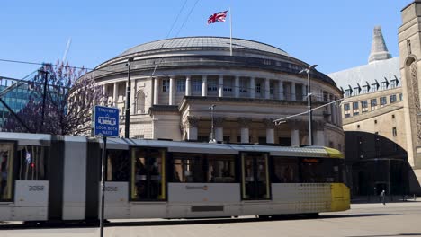 Tram,-bike-and-pedestrians-by-Manchester-Central-Library-with-UK-flag