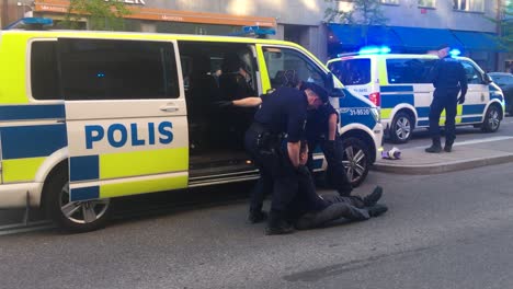 Schwedische-Polizei-Hebt-Festgenommenen-Demonstranten-In-Auto-Auf-Stockholmer-Straße