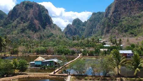 Aerial-of-beautiful-hidden-gem-traditional-Rammang-Rammang-Village-with-giant-limestone-cliffs-and-huge-karst-mountains-in-Sulawesi,-Indonesia