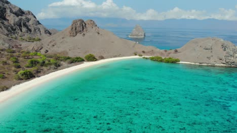 Malerische-Aussicht-Auf-Den-Rosa-Strand-Mit-Schroffen-Hügeln-Und-Türkisfarbenem-Wasser-Auf-Der-Insel-Padar-Im-Komodo-Nationalpark,-Indonesien