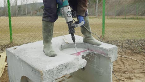 El-Constructor-Trabajador-Masculino-Utiliza-Un-Taladro-De-Impacto-Eléctrico-Para-Demoler-Pozos-De-Hormigón-Prefabricados-En-Cámara-Lenta