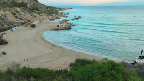 Crepúsculo-En-La-Playa-De-Konnos,-Ayia-Napa,-Chipre,-Con-Orillas-Arenosas-Y-Aguas-Cristalinas.
