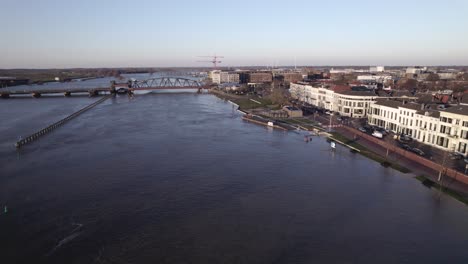 River-IJssel-being-twice-its-size-during-high-water-levels-in-winter-rains-seen-from-above-passing-countenance-boulevard-of-Zutphen,-The-Netherlands