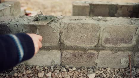 La-Mano-De-Un-Hombre-Cementando-Una-Capa-De-Ladrillo.