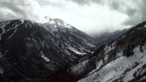 Aspen-Snowmass-Buttermilk-glacier-scenic-landscape-view-Highlands-Bowl-ski-trails-Pyramid-Peak-Maroon-Bells-Capital-peak-Colorado-winter-fog-cloudy-snowy-pan-to-the-left-slowly