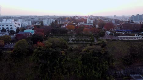 Vista-Del-Atardecer-Sobre-Una-Zona-Residencial-Con-árboles-Otoñales,-Toma-Aérea,-Ambiente-Tranquilo