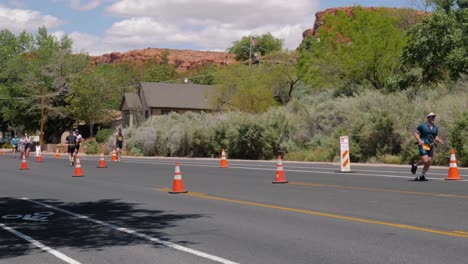 Cyclist-in-red-shirt-and-runners-at-the-Intermountain-Health-IRONMAN-70