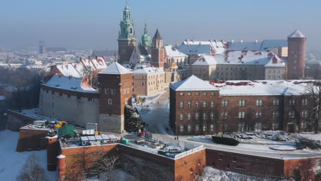 Snow-covered-Wawel-castle-at-magic-morning-with-soft-sun-light-during-winter,-Krakow,-Poland
