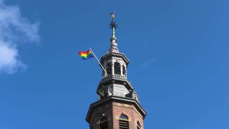 Rainbow-flag-on-a-church-bell-tower-in-Amsterdam,-Holland